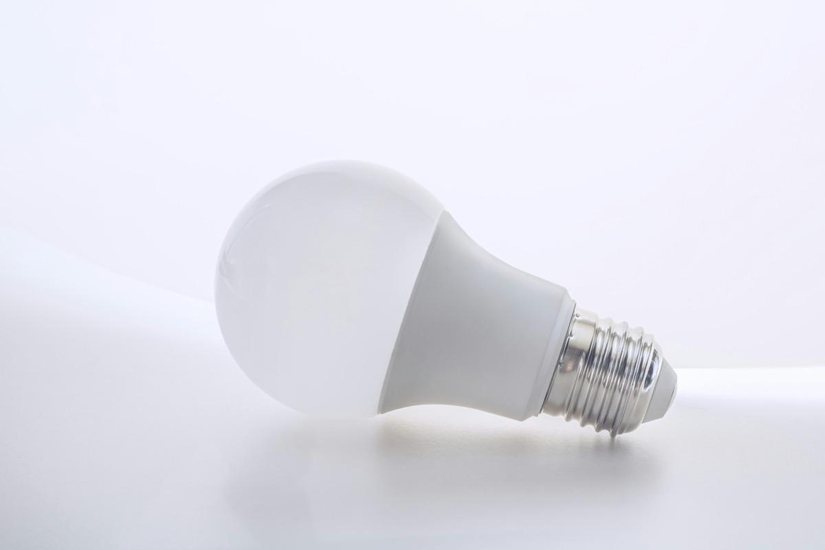Ampoule LED unique sur fond blanc uni
