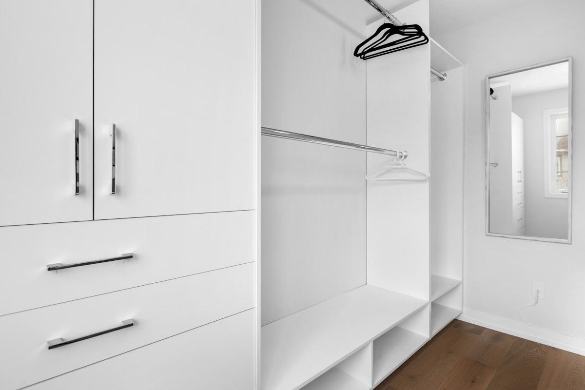 Dressing blanc organisé avec penderie et casiers de rangement