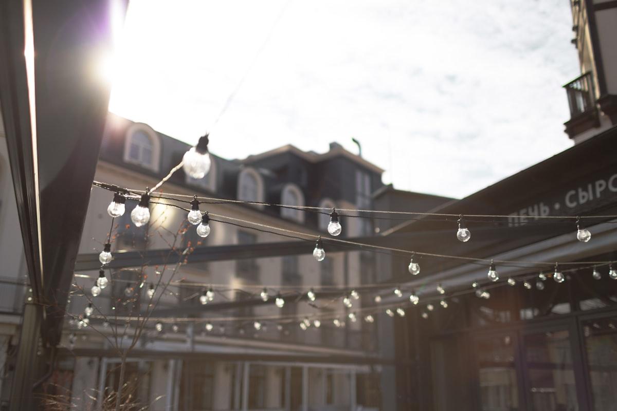 Guirlande lumineuse tendue au-dessus d'une terrasse en plein jour
