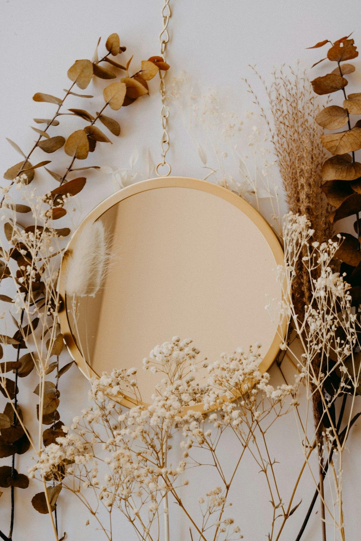 Miroir rond à cadre laiton entouré de fleurs séchées