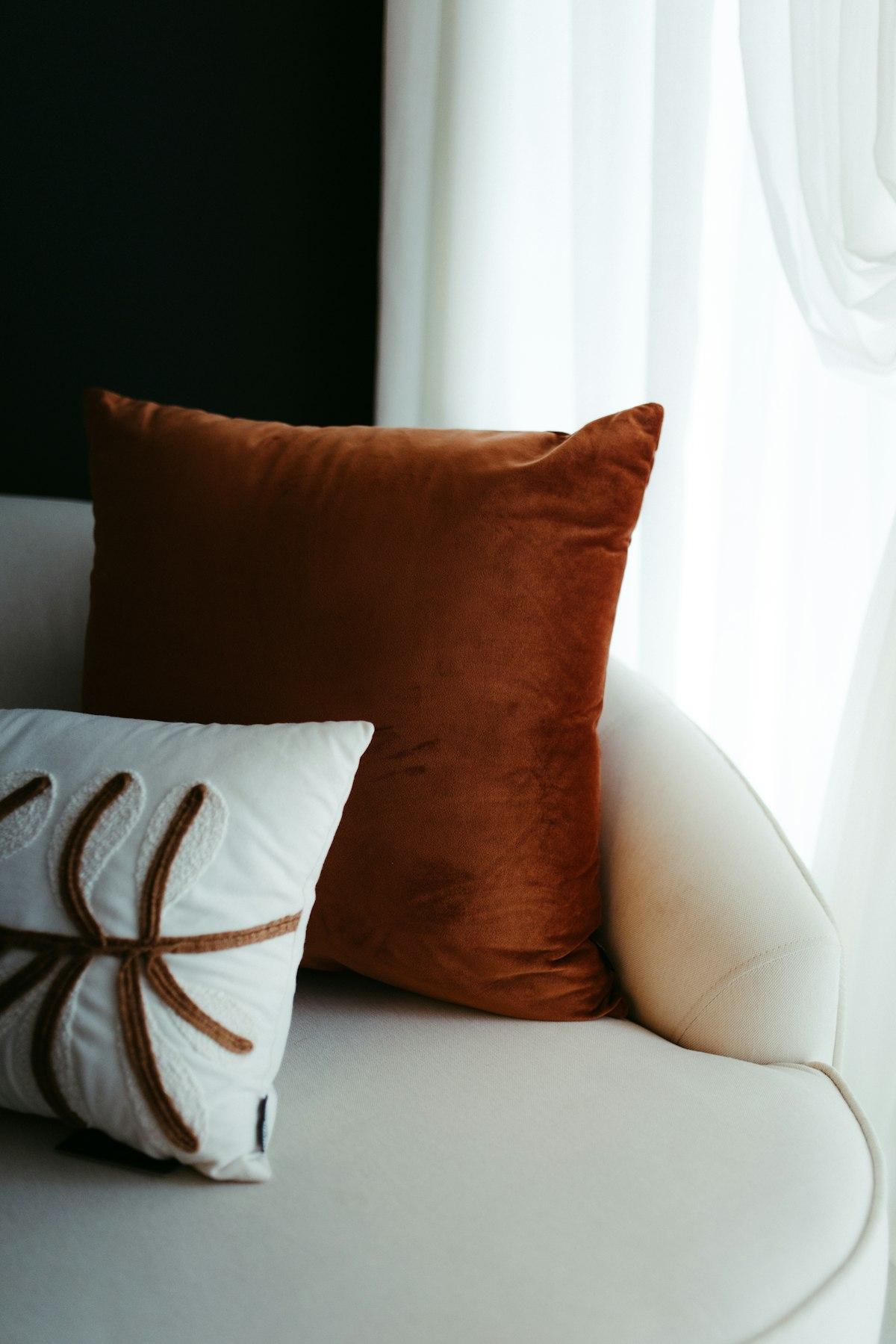 Coussin en velours terracotta sur un canapé écru